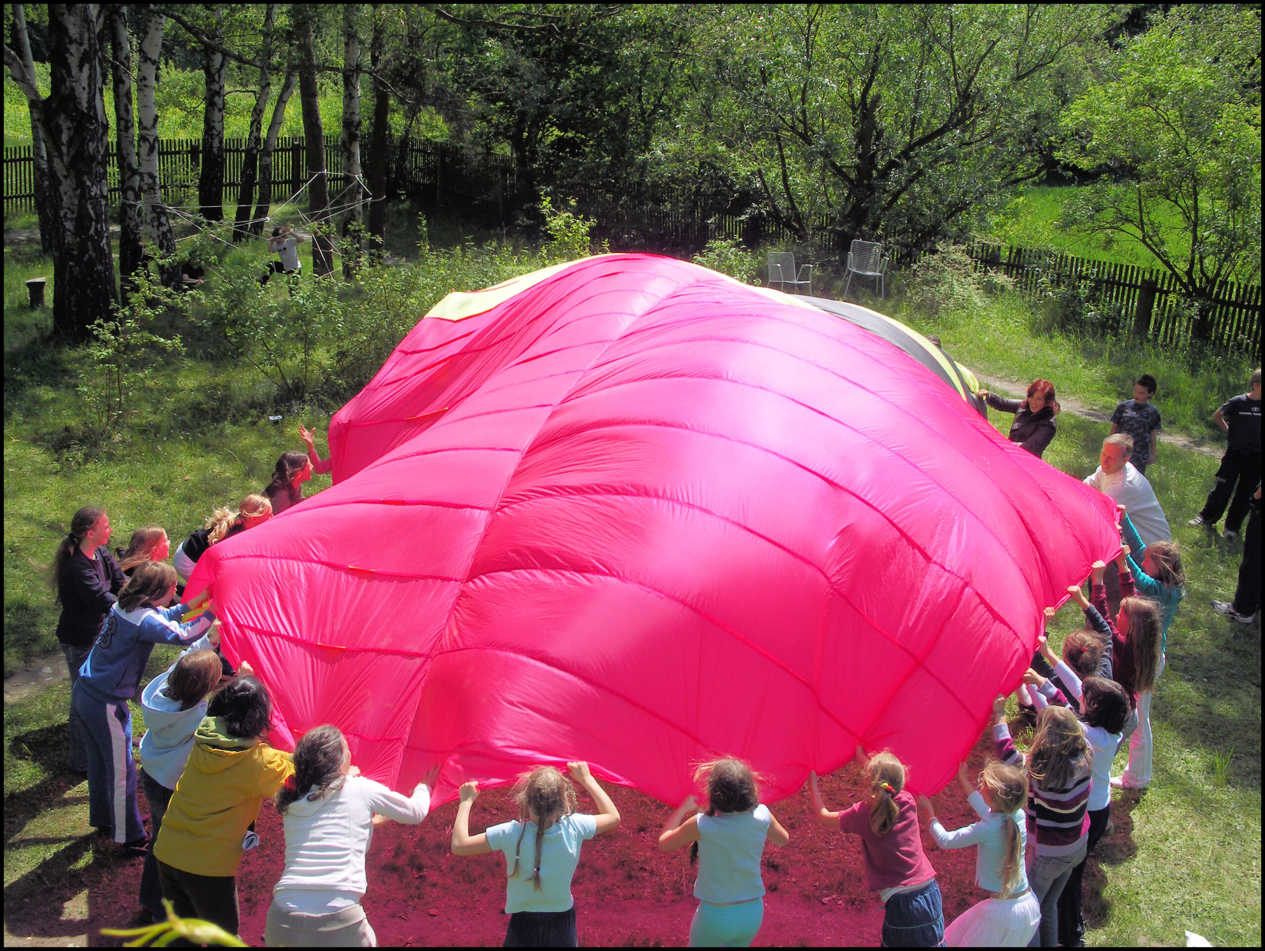 Children play together in a circle with a large cloth